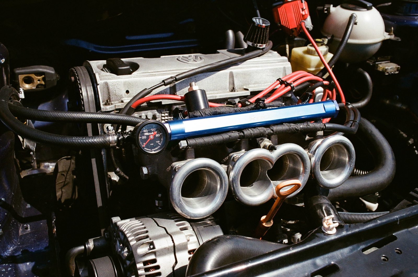ABA 8-valve engine with individual throttle bodies, a blue fuel rail, and red ignition wires